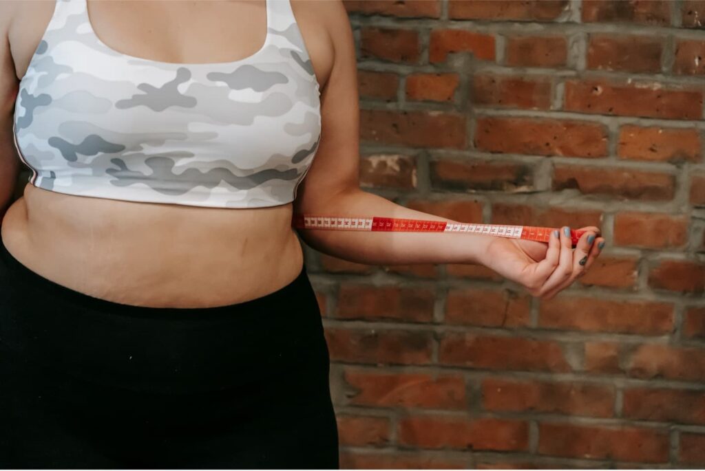 Woman Measuring Her Waist with a Measuring Tape Wanting to Lose Weight
